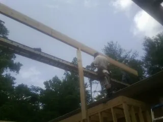 Carpenter setting a ridge beam over a new addition frame — Ice Dam Removal by Roofing Brothers in Helmetta