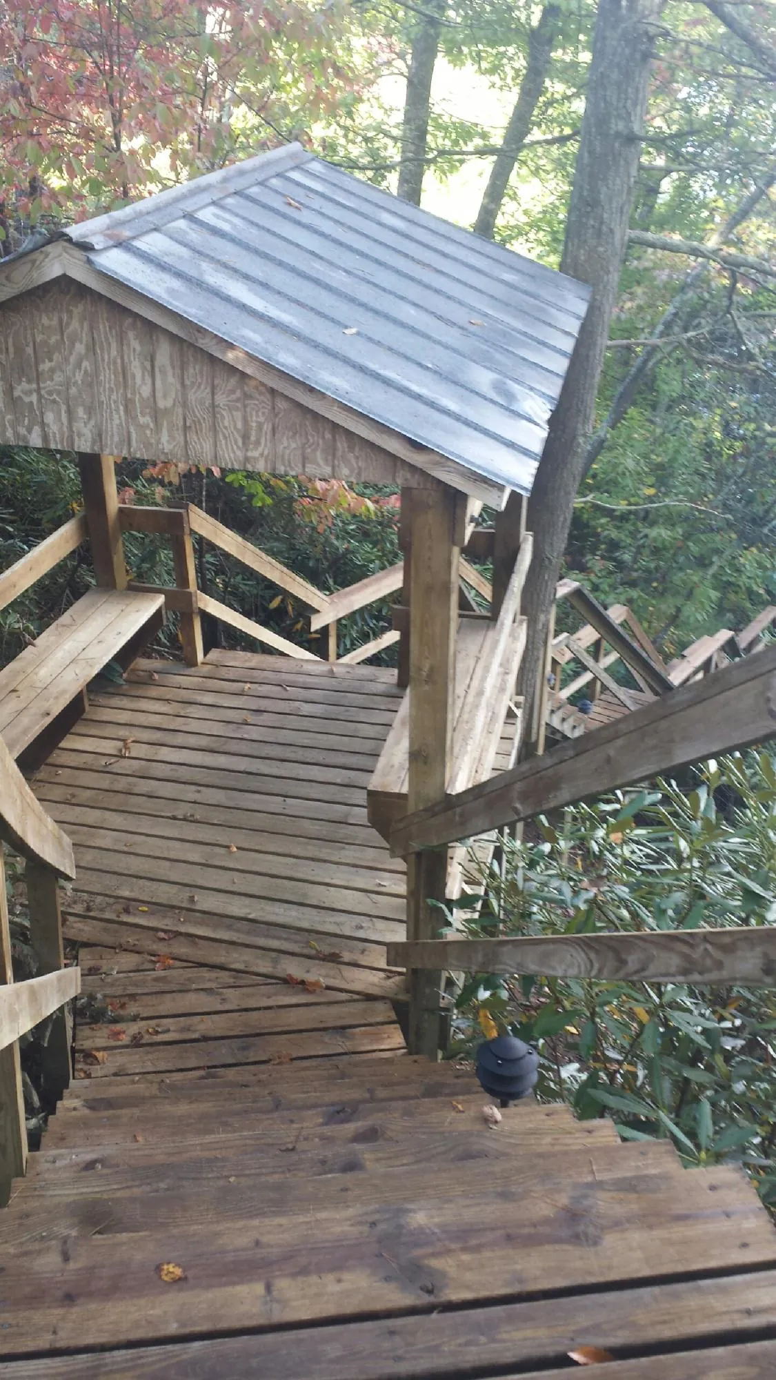 Metal roofed shelter over wooden steps on a wooded walkway — Skylight Repair & Installation work by our crew in Helmetta