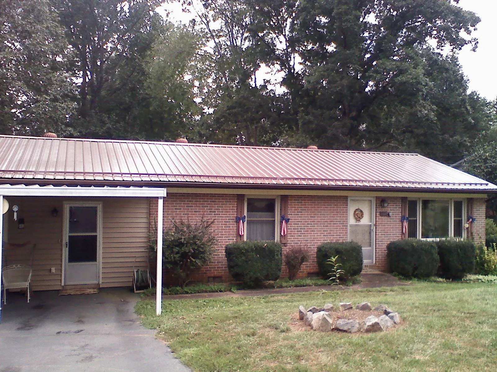 Bronze metal roof and carport on a brick ranch home — Roof Repair work by our crew in Helmetta